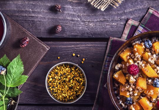 Healthy breakfast with pumpkin porridge, berries and herbal tea with honey at village summer house