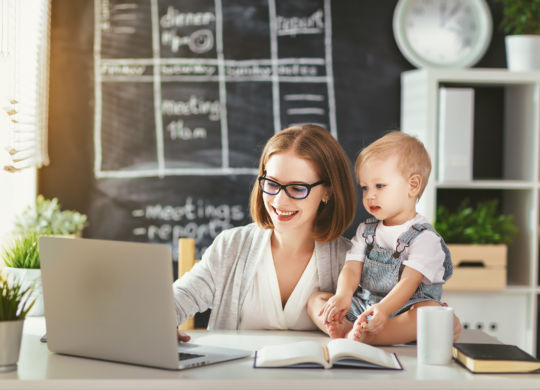 Businesswoman mother  woman with a toddler working at the computer