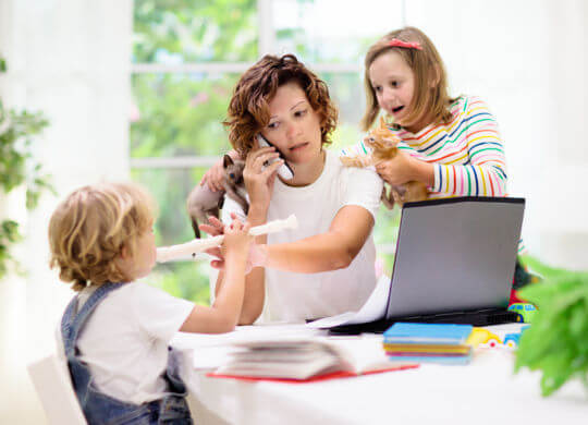 Mother working from home with kids. Quarantine and closed school during coronavirus outbreak. Children make noise and disturb woman at work. Homeschooling and freelance job. Boy and girl playing.