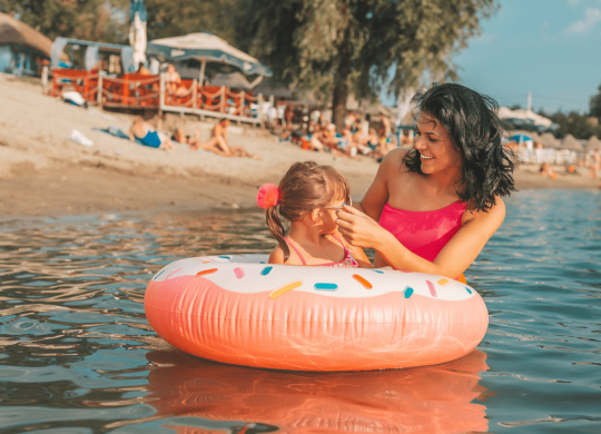 Mutter badet mit Kind im see
